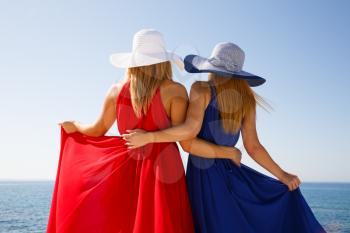 Blond women in the red and blue dresses at the beach in Cyprus.