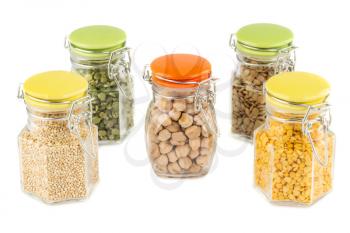 The collection of different groats in the glass jars isolated on white background. Split peas, quinoa, chickpea and lentils.