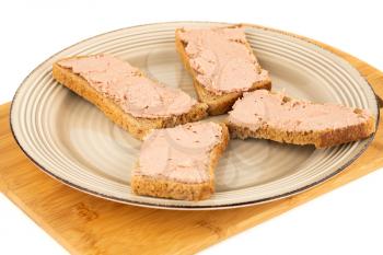 Sandwiches with pate on plate on wooden board.