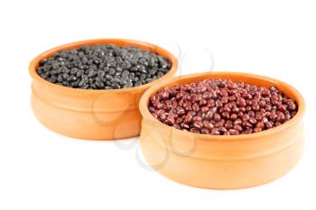 Black turtle and adzuki beans in the ceramic pots isolated on a white background.