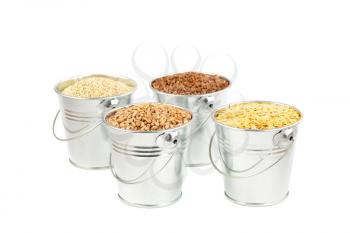 The collection of different groats in the gray metallic buckets isolated on white background. Quinoa, buckwheat, wheat and golden lentil.