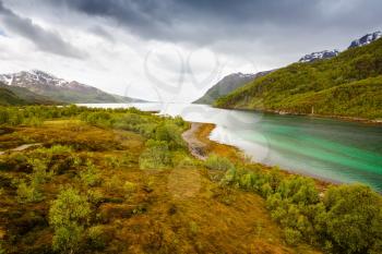 Landscape with fjord and mountains in Norway, foggy day.
