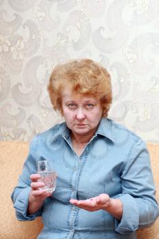 Senior lady woman with medication pills in room.