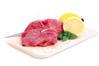 Cut of  beef steak, knife  with lemon slice. Isolated.