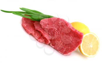 Cut of  beef steak with lemon slice and onion. Isolated.