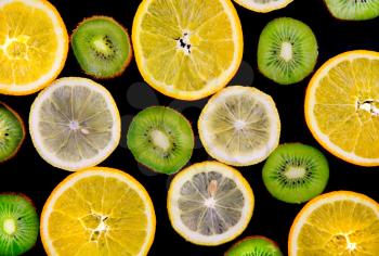Background texture-fruit mix: lemon, orange, kiwi on black background.