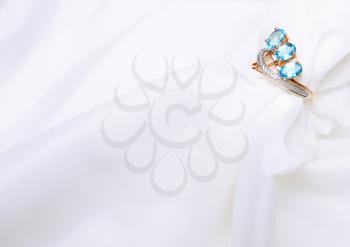 Golden Ring with sapphire on white silk.