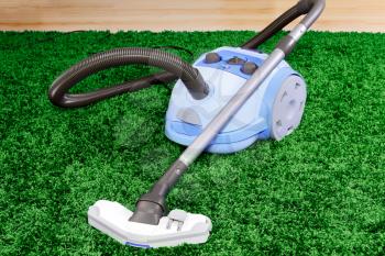 Vacuum cleaner stand  on green  carpet