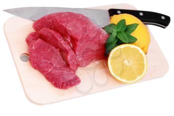 Cut of  beef steak, knife  with lemon slice. Isolated.