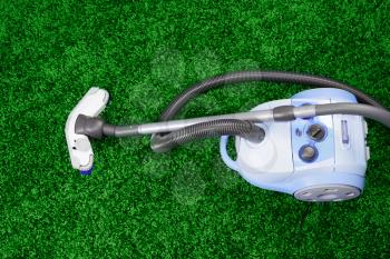 Vacuum cleaner stand  on green carpet