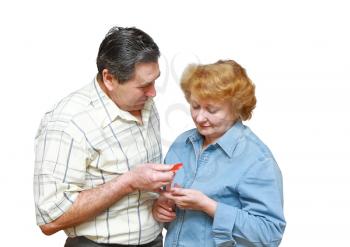 Old couple,husband gives to his wife a small heart.Isolated over white