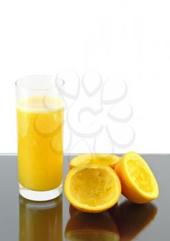 Glass of fresh orange juice with squeeze slice on grey background..