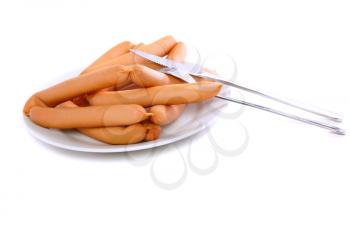 A fresh sausage on white plate with fork and knife. Isolated over white.