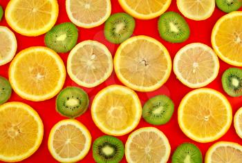Background texture-fruit mix: lemon, orange, kiwi on red background.