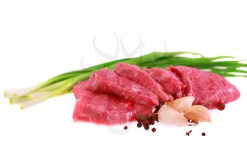 Cut of  beef steak  with garlic  slice, onion and laurel. Isolated.