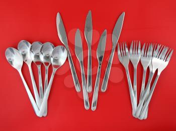 Table serving-knife,plate,fork and   on  red background.