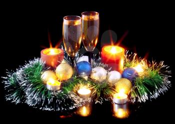 Christmas and New Year decoration- balls, tinsel, candel and glasses of champagne .On black background.