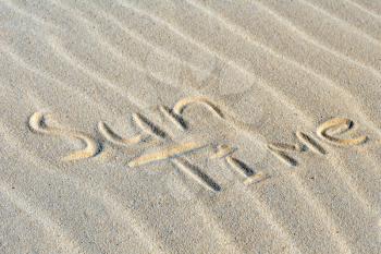 Inscription Sun Time on a sand on beach