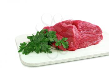 Cut of  beef steak  on meat hardboard and green leaf. Isolated.