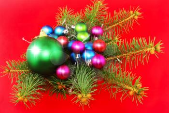 Christmas and New Year decoration-balls with fir branches and candels on red background .