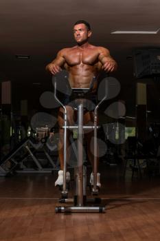 male bodybuilder using the elliptical machine