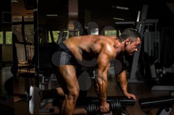 male bodybuilder doing heavy weight exercise for back