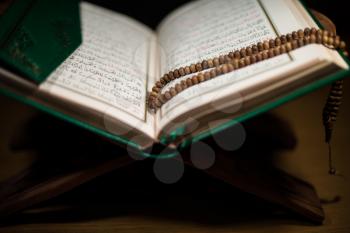 pages of holy koran and rosary at the book