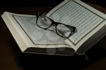 pages of holy koran and geek glasses