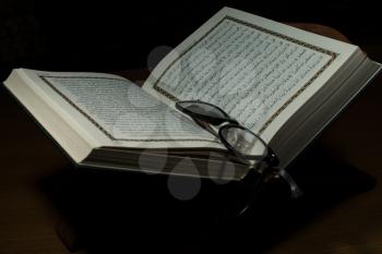 pages of holy koran and geek glasses