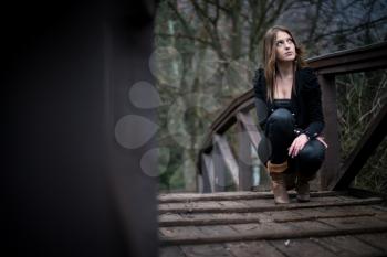 young woman crouch at bridge
