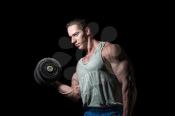 young bodybuilder doing heavy weight exercise for biceps with dumbbell