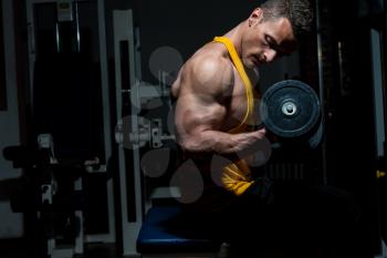 young man doing heavy weight exercise for biceps