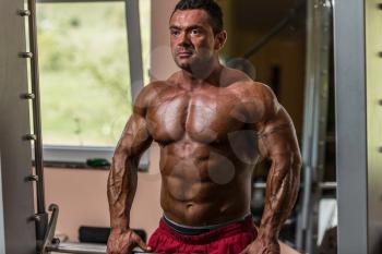 male bodybuilder doing heavy weight exercise for trap
