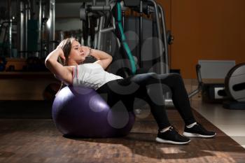 Young Woman Exercising Abdominals In Fitness Club