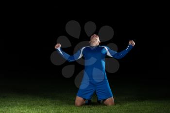 Man Soccer Player Celebrating Victory In Blue Uniform On Black Background