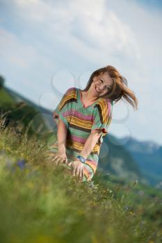 beautiful woman in dress sitting on the grass