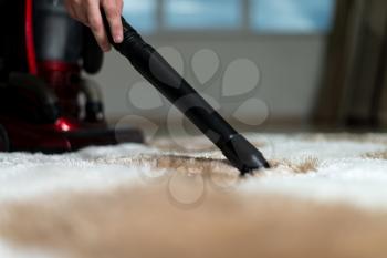 Man Cleaning Carpet With A Vacuum Cleaner