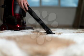 Man Cleaning Carpet With A Vacuum Cleaner