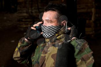 Paintball player calling someone at the phone