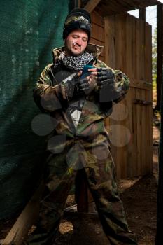Paintball player smoking a cigarette in the woods