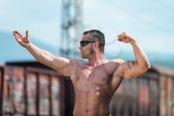 Body Builder Posing At The Railroad