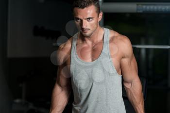 Muscular Man Exercising Biceps In Gym
