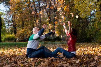 Loving Couple Toss The Leaves In Autumn Park