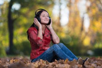 Young Woman Listening To Music In Nature
