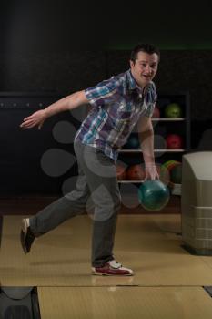Smiling Young Man Playing With A Bowling Ball