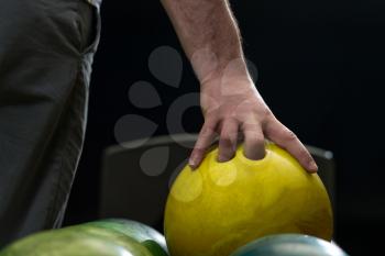 Holding Ball Against Bowling Alley