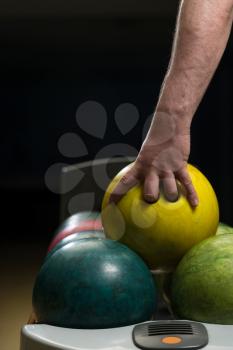 Holding Ball Against Bowling Alley