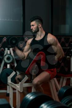 Men In Gym Exercising With Dumbbells