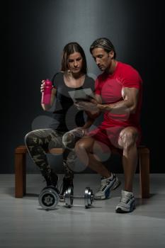Fit Couple Looking At Digital Table In A Studio On A Black Background