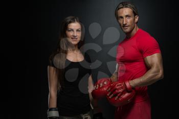 Bodybuilding Couple Posing With Boxing Gloves On Black Background